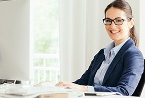 Woman at an office desk wearing VDU glasses
