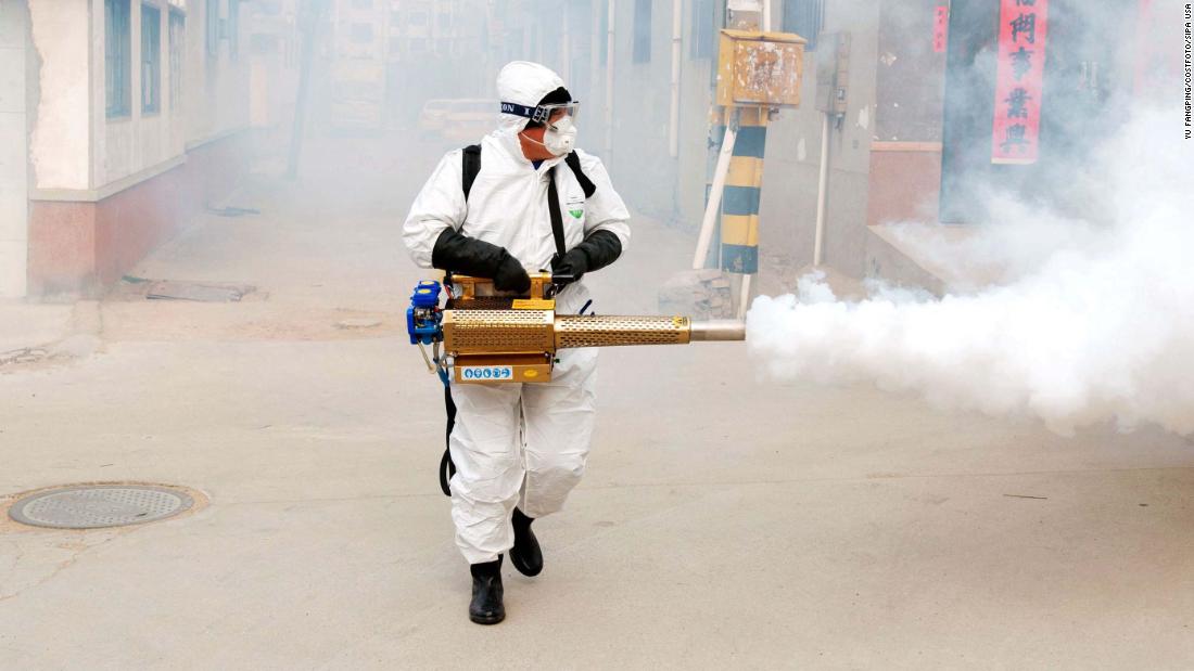 A volunteer wearing protective clothing disinfects a street in Qingdao, China, on January 29.