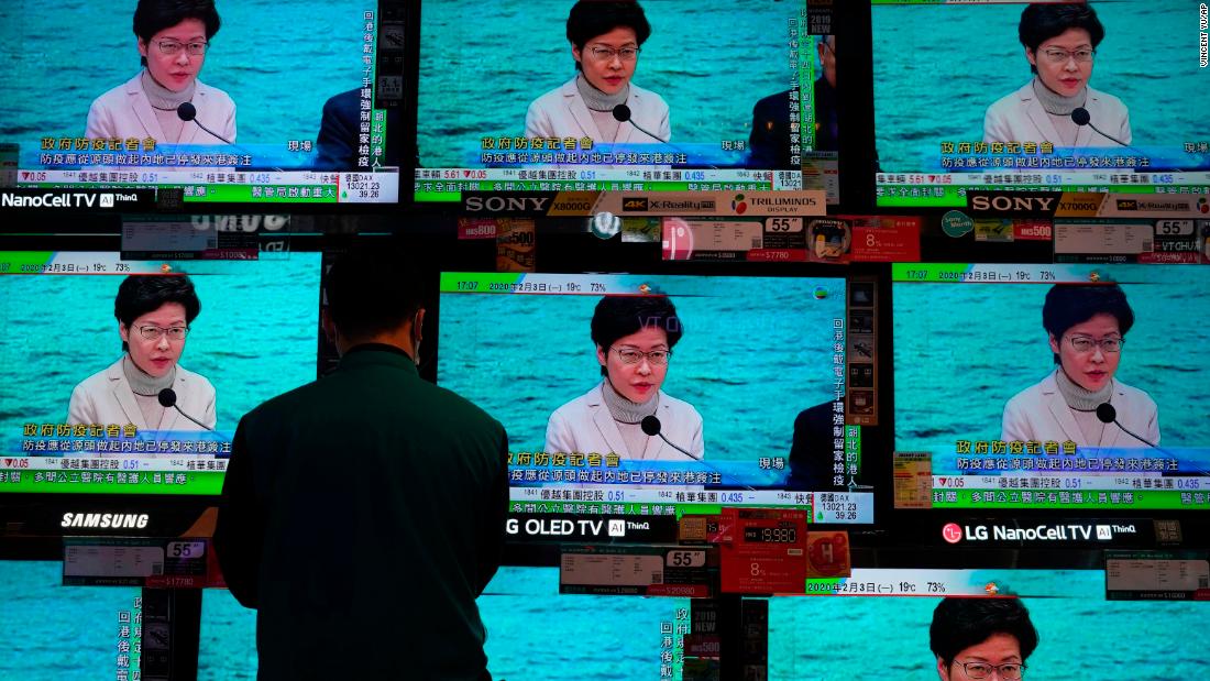 A man stands in front of TV screens broadcasting a speech by Hong Kong Chief Executive Carrie Lam on February 3. Lam said the city would shut almost all border-control points to the mainland.