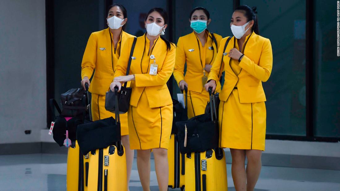 Flight attendants wearing face masks make their way through Don Mueang Airport in Bangkok on February 7.