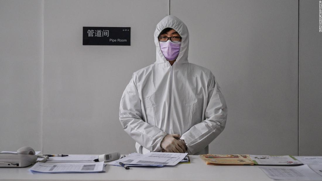 A worker wears a protective suit as he waits to screen people entering an office building in Beijing on February 10. China&#39;s workforce is &lt;a href=&quot;https://edition.cnn.com/2020/02/10/business/china-companies-return-to-work-coronavirus/index.html&quot; target=&quot;_blank&quot;&gt;slowly coming back to work&lt;/a&gt; after the coronavirus outbreak forced many parts of the country to extend the Lunar New Year holiday by more than a week.