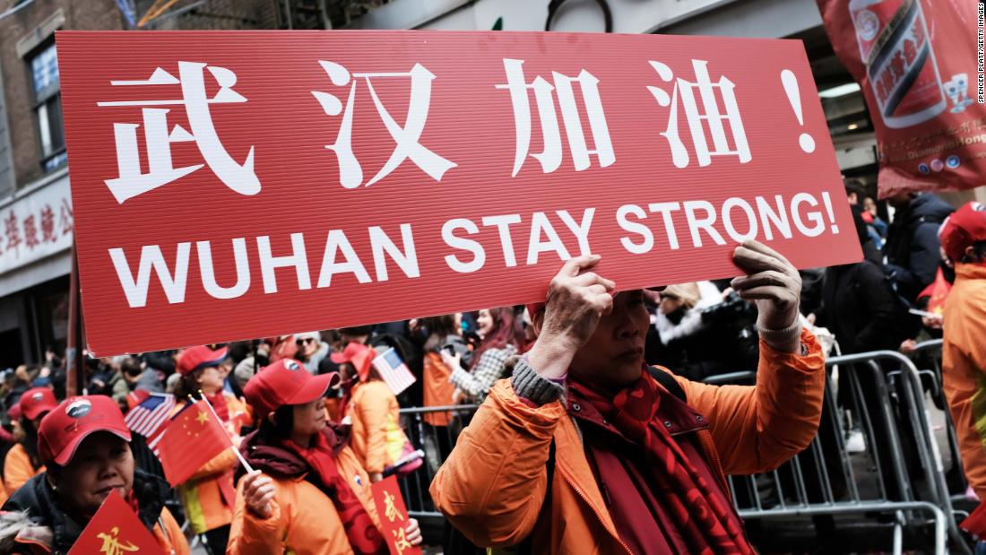 People participating in a Lunar New Year Parade in New York City hold signs reading, &quot;Wuhan stay strong!&quot; on February 9.