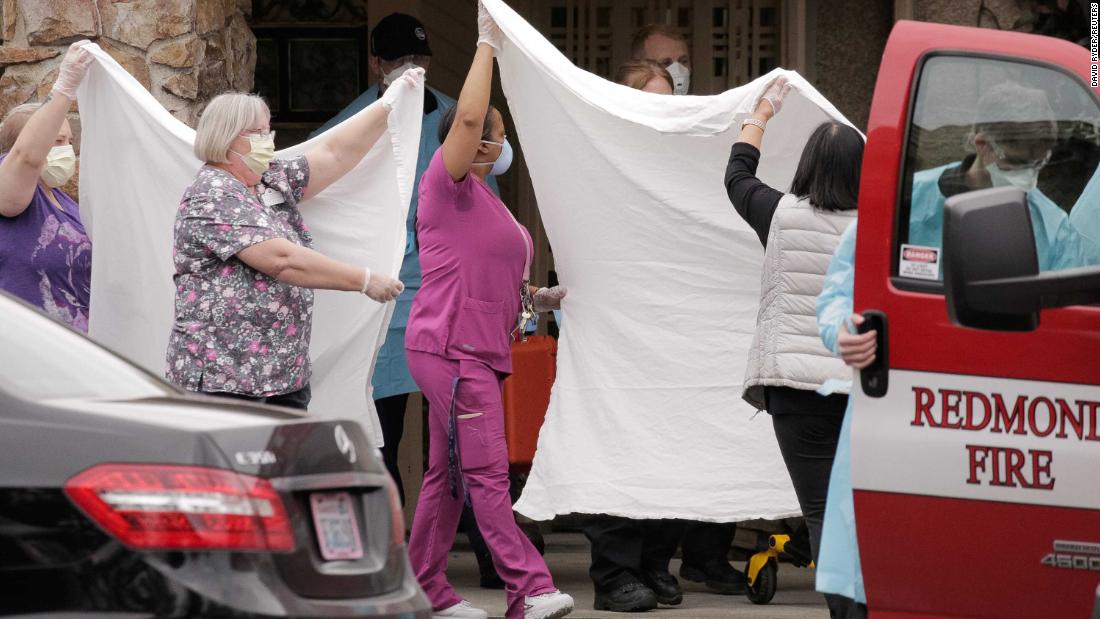 Health care workers transfer a patient at the Life Care Center in Kirkland, Washington, on March 1. The long-term care facility is linked to confirmed coronavirus cases.