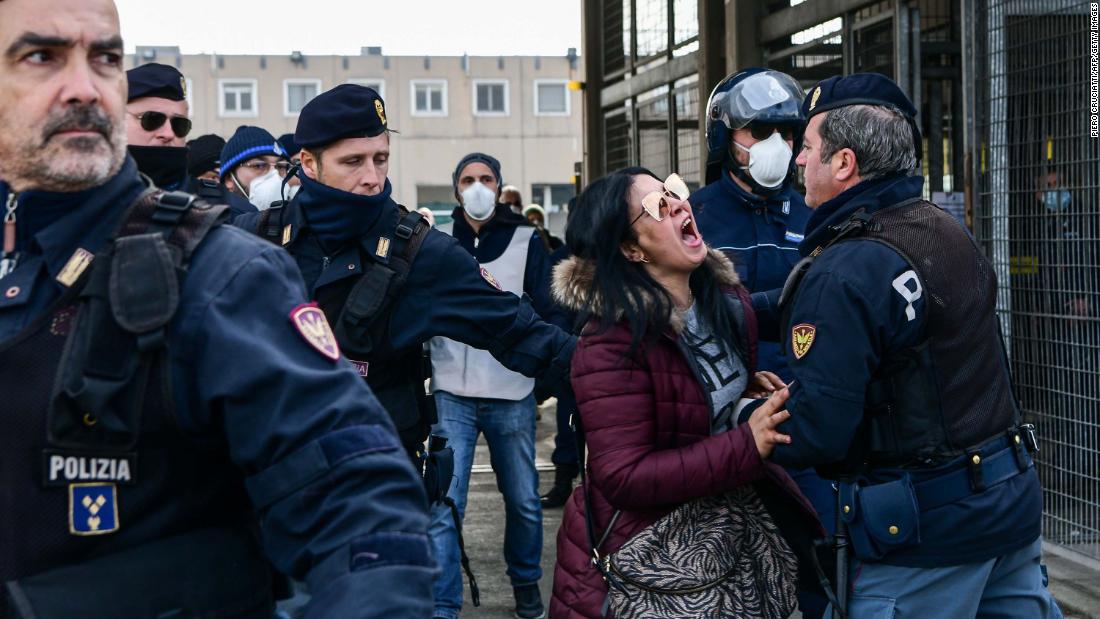 Police officers restrain the relative of an inmate outside the Sant&#39;Anna jail in Modena, Italy, on March 9. &lt;a href=&quot;https://www.cnn.com/asia/live-news/coronavirus-outbreak-03-09-20-intl-hnk/h_950c62671e245816c223fb84f1306fe6&quot; target=&quot;_blank&quot;&gt;Riots broke out&lt;/a&gt; in several Italian jails after visits were suspended to curb the spread of the coronavirus.
