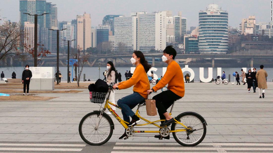 A couple rides a bicycle at a park in Seoul, South Korea, on March 7. 