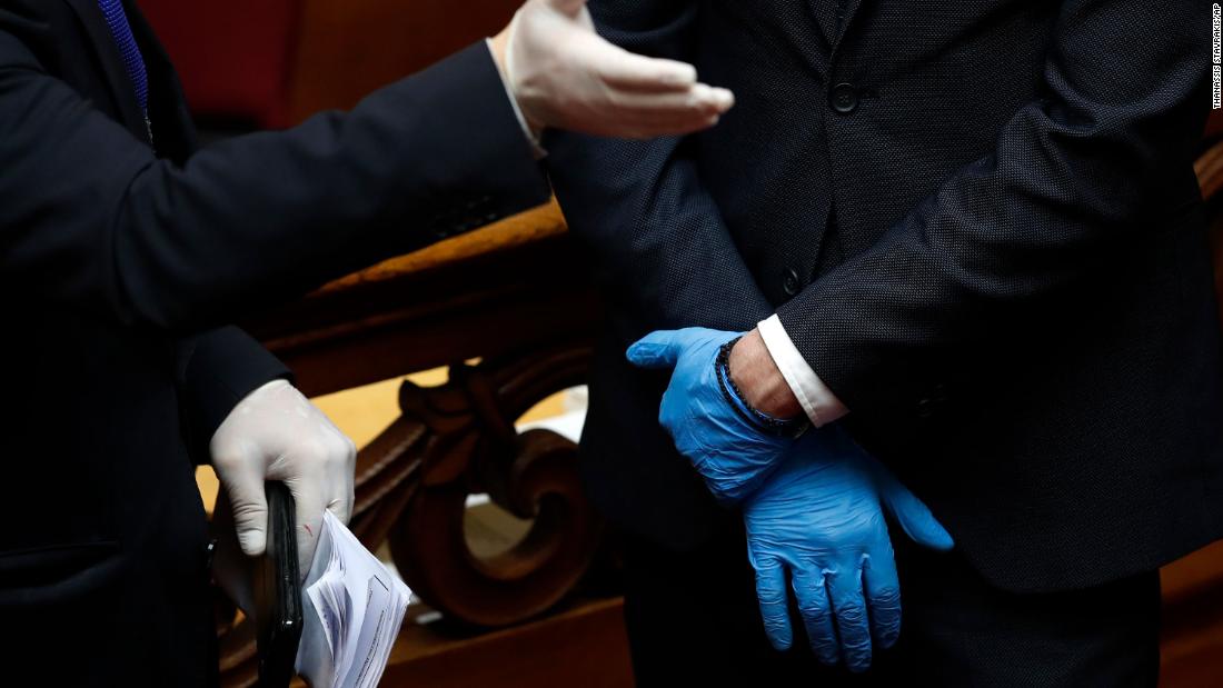 Employees of the Greek Parliament wear plastic gloves ahead of the swearing-in ceremony for Greek President Katerina Sakellaropoulou.