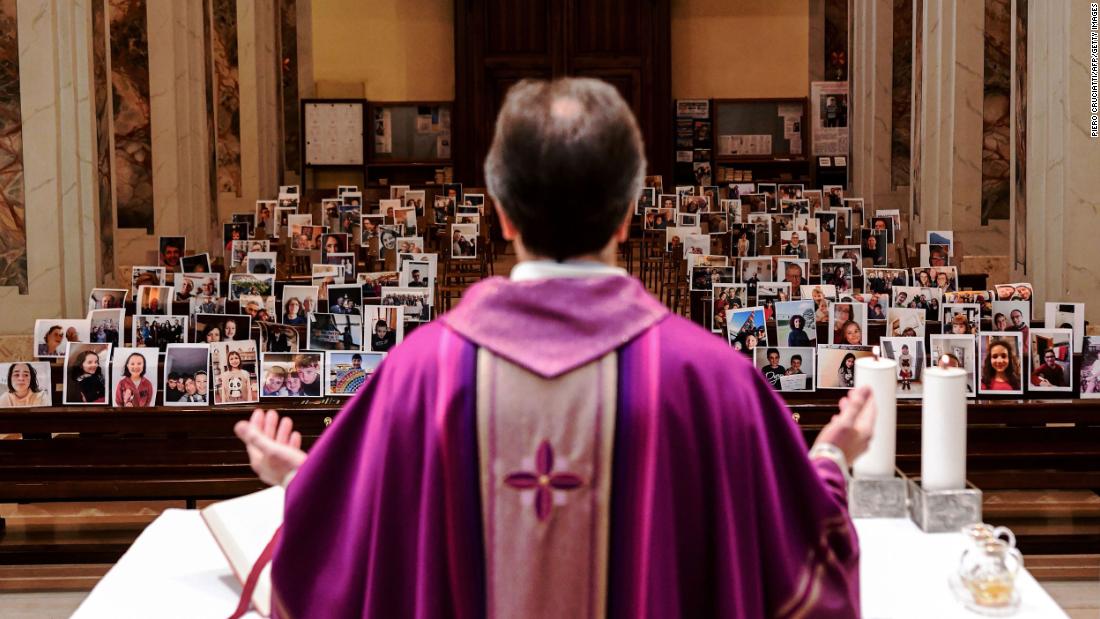 Giuseppe Corbari holds Sunday Mass in front of photographs sent in by his congregation members in Giussano, Italy, on March 22. Many religious services are being streamed online so that people can worship while still maintaining their distance from others.