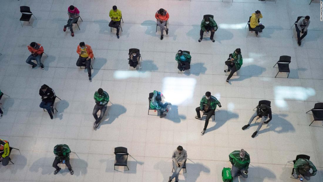 People practice social distancing as they wait for takeout food at a shopping mall in Bangkok, Thailand, on March 24.