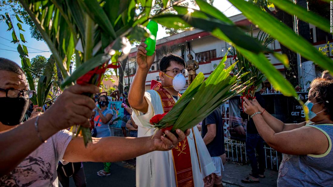 A Catholic priest sprinkles holy water on devotees during Palm Sunday celebrations in Quezon City, Philippines, on Sunday, April 5.