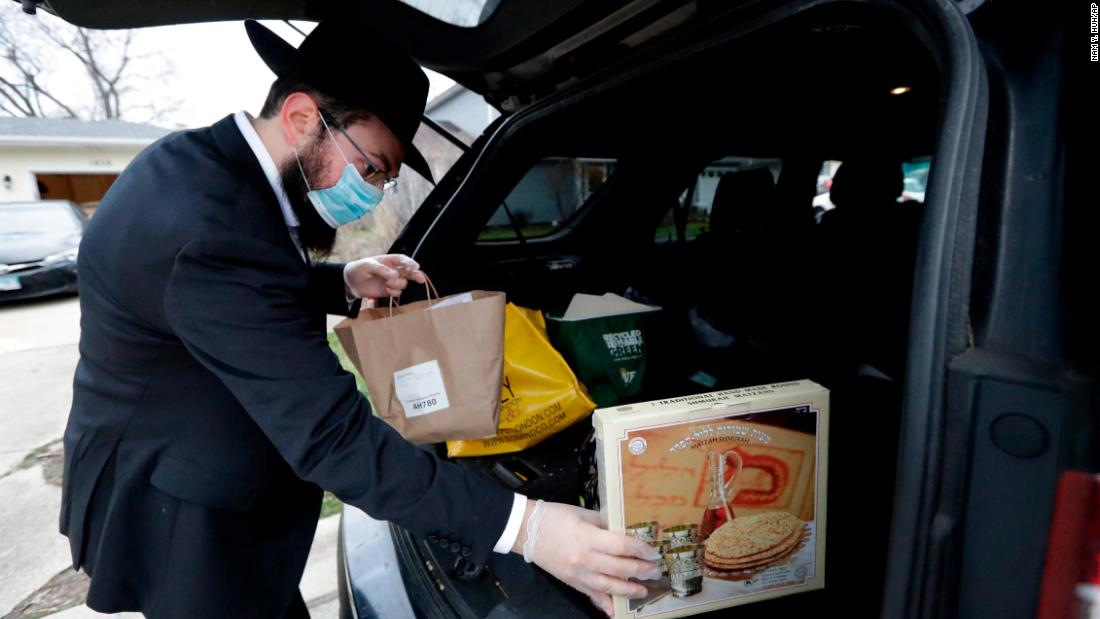 Rabbi Yaakov Kotlarsky places Passover Seder to-go packages into a car trunk in Arlington Heights, Illinois, on April 7.