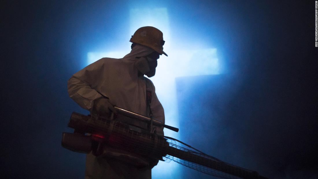 A worker disinfects a carved cross at the Salt Cathedral in Zipaquira, Colombia, on April 8.