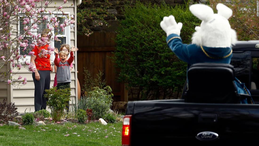Children wave to a person dressed as the Easter Bunny during a neighborhood parade in Haverford, Pennsylvania, on April 10.