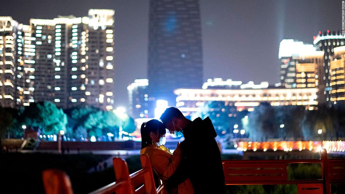 A couple stands in a park along the Yangtze River in Wuhan, China.
