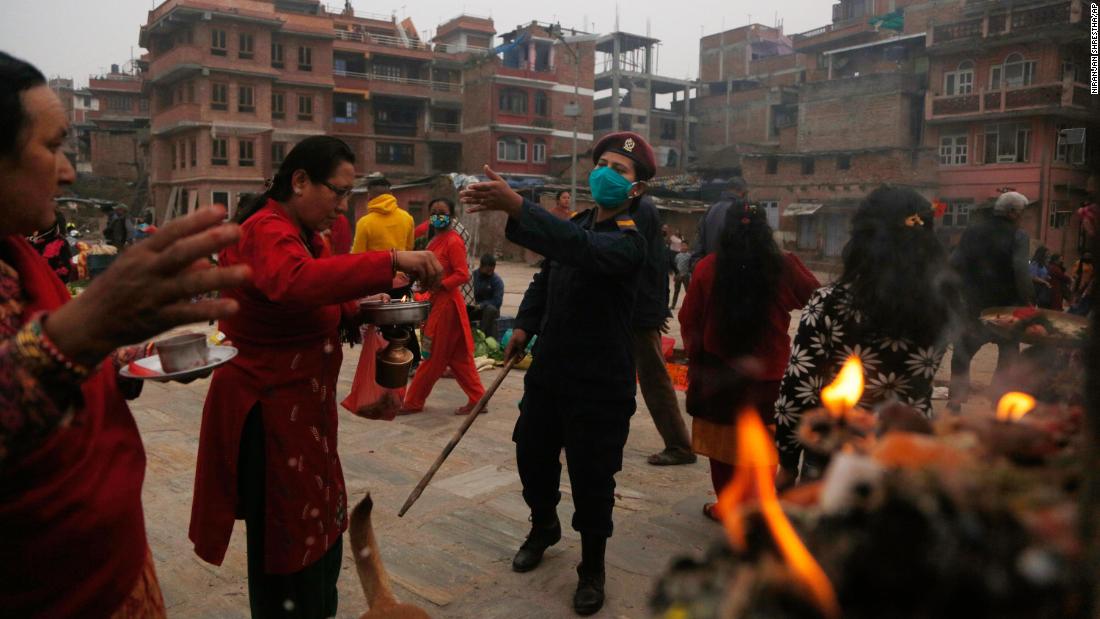 A police officer requests that people return to return to their homes during a gathering that marked the Bisket Jatra festival in Bhaktapur, Nepal.