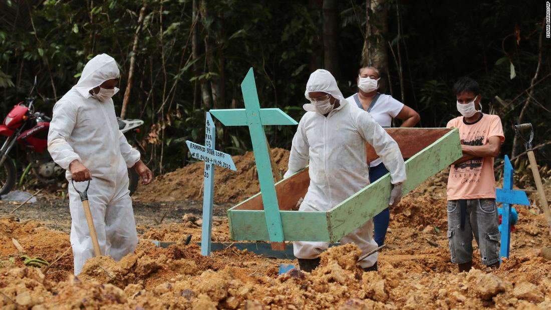 Funeral workers in Manaus, Brazil, prepare the grave of a woman who is suspected to have died from the coronavirus.