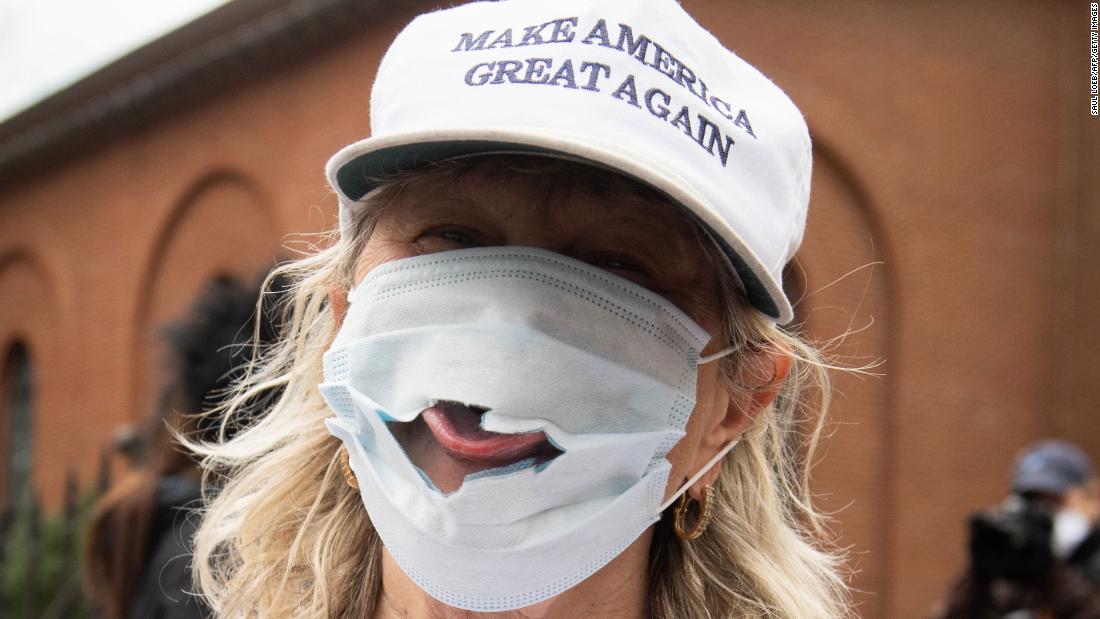 A woman sticks her tongue out of a torn mask at a Reopen Maryland rally outside the State House in Annapolis, Maryland, on April 18. Residents in multiple states have been protesting stay-at-home orders.