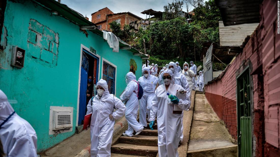 Mayor&#39;s office workers wear protective suits as they conduct a census in a Bogota, Colombia, neighborhood on April 19. They were trying to find out how many families needed to be provided with food.