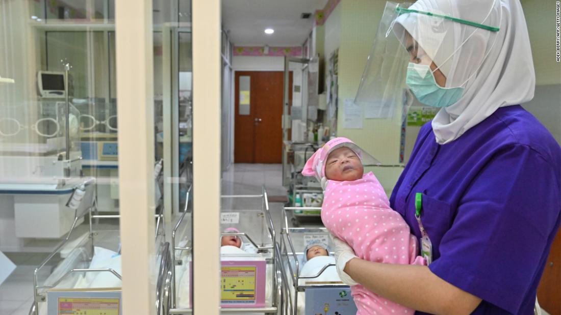 A nurse holds a newborn baby, wearing a face shield as a protective measure, at a maternity facility in Jakarta, Indonesia, on April 21.
