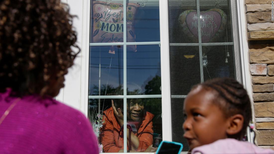 Mary Washington speaks through a window to her daughter Courtney Crosby and grandchild Sydney Crosby during a Mother&#39;s Day celebration at her senior-living facility in Smyrna.