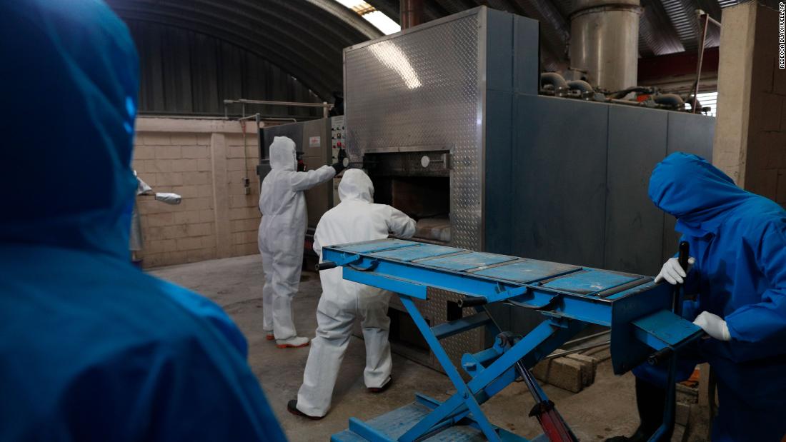 Workers wear protective gear as they start a cremation oven in Ecatepec, Mexico, on May 21.