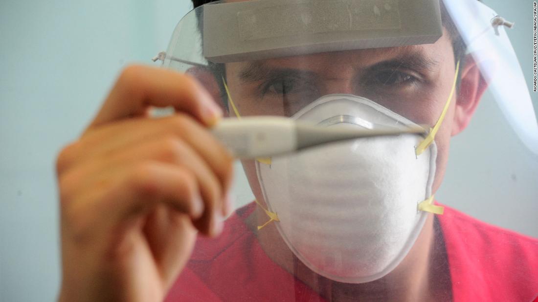 A health worker wears a face shield while checking a patient&#39;s temperature at a hospital in Toluca, Mexico, on May 21. Mexico had reported its highest number of new daily cases.