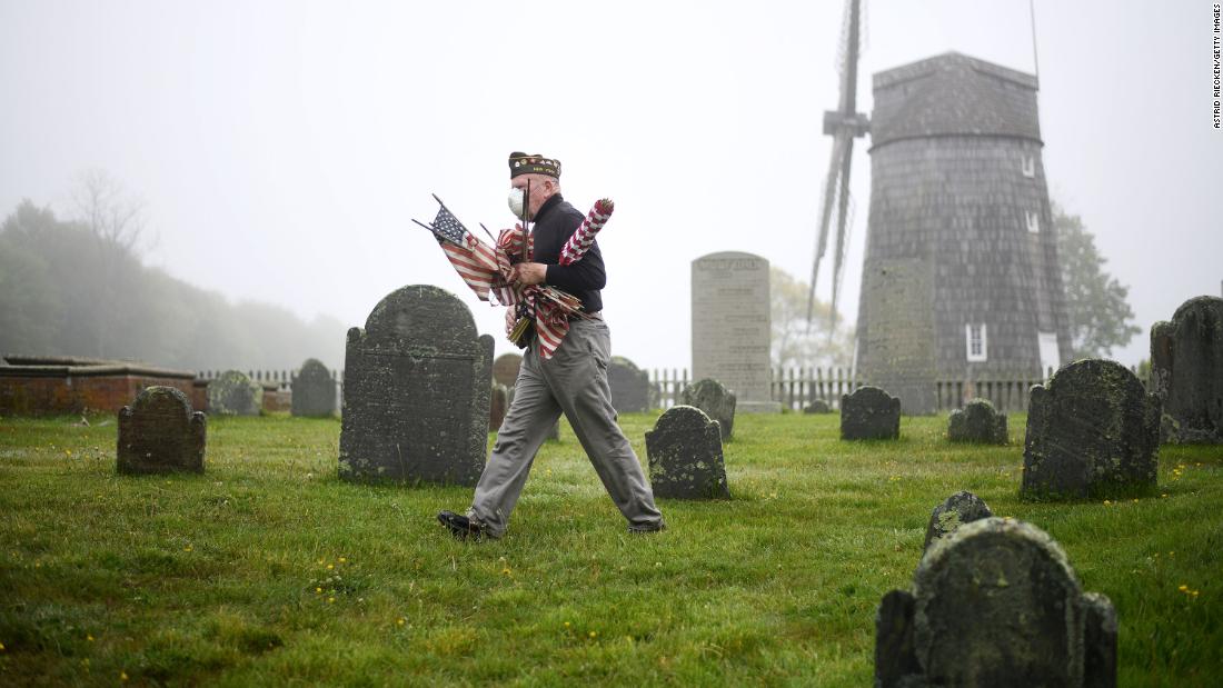 Brian Carabine, a retired US Marine, replaces flags at the South End Cemetery in East Hampton, New York, just before Memorial Day.