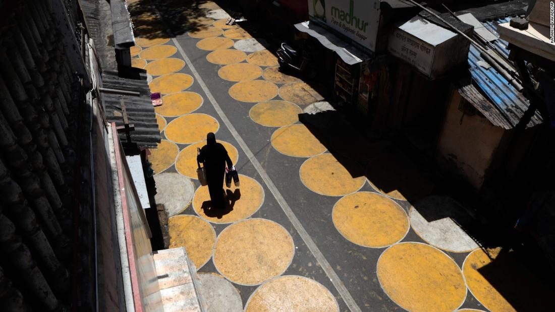 A woman walks along a road painted with circles to help people maintain social distancing in Mumbai, India, on June 29.